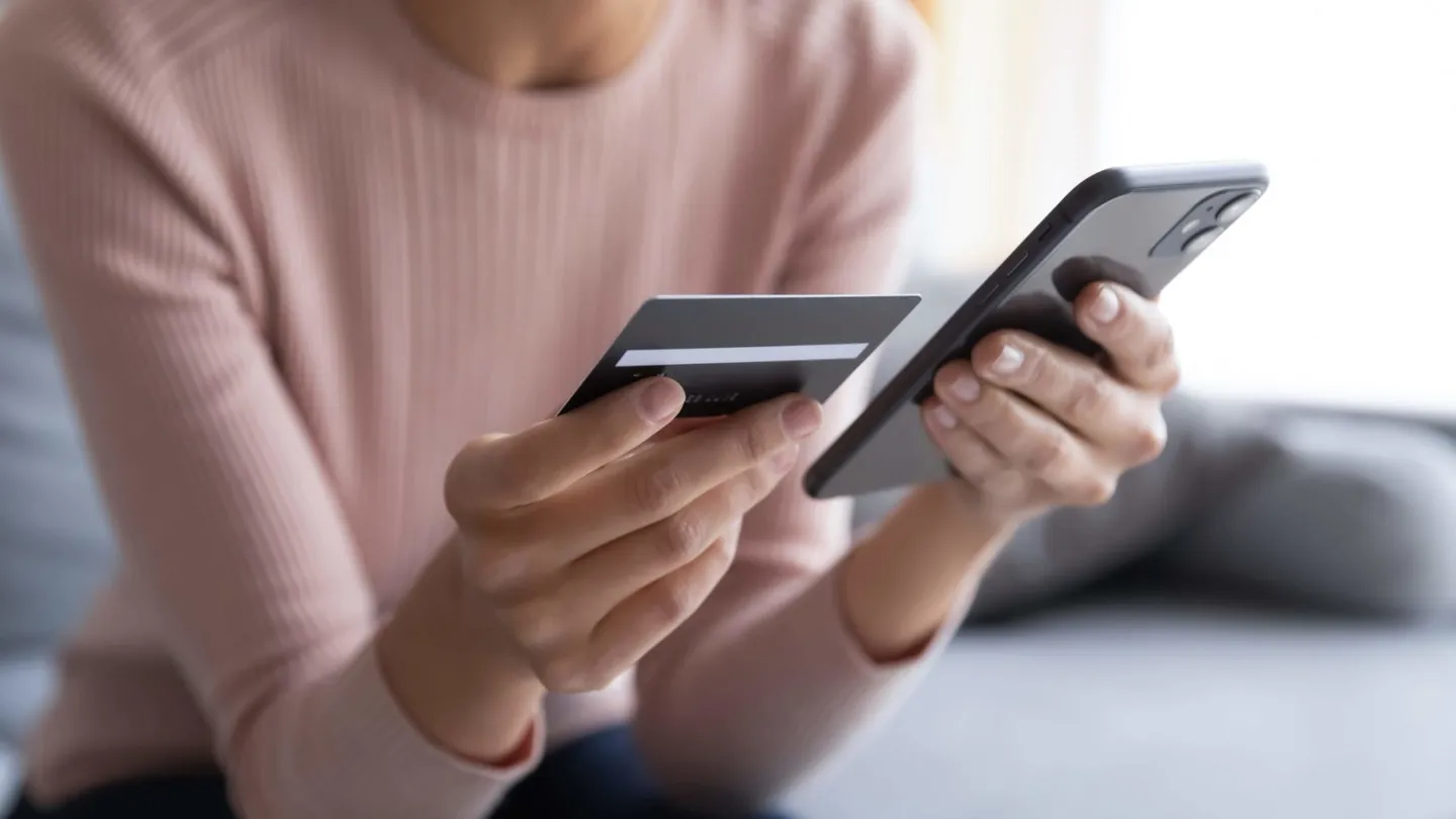 Guest paying the shipping fees for her lost item by bank card on her smartphone